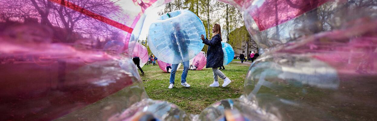 kuvituskuva, jossa rantapallon läpi näkyy ihmisiä