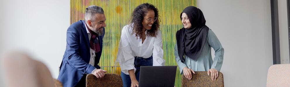 Kolme henkilöä työskentelee yhdessä.